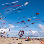 Kites being flown in the Otaki Beach Kite Festival 2024. Blue sky sunny day in New Zealand